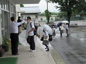 雨の中、登校、検温